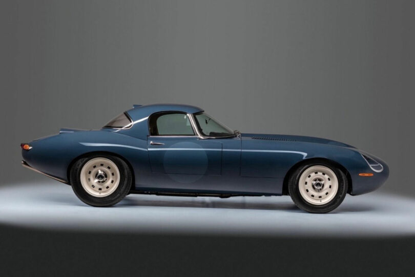 A classic blue sports car with a hardtop, designed by Neil Ferrier, viewed from the side and positioned on a light gray background.